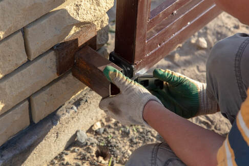 An image of a person working on a gate installation service